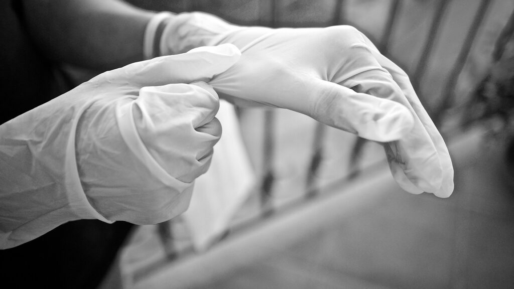 Kirurgisia suojakäsineitä puetaan käteen.